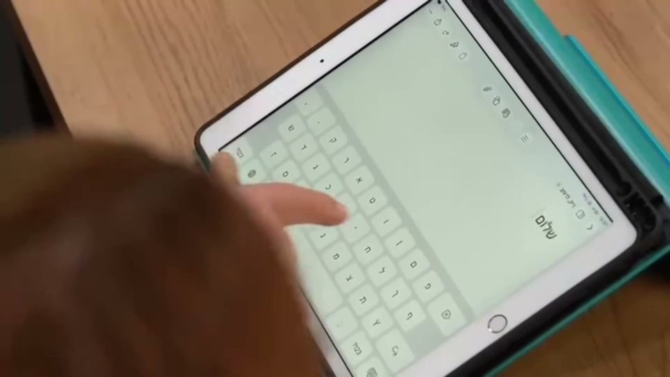 יד מצביעה על מקלדת באייפד בזמן שיעור הקלדה
